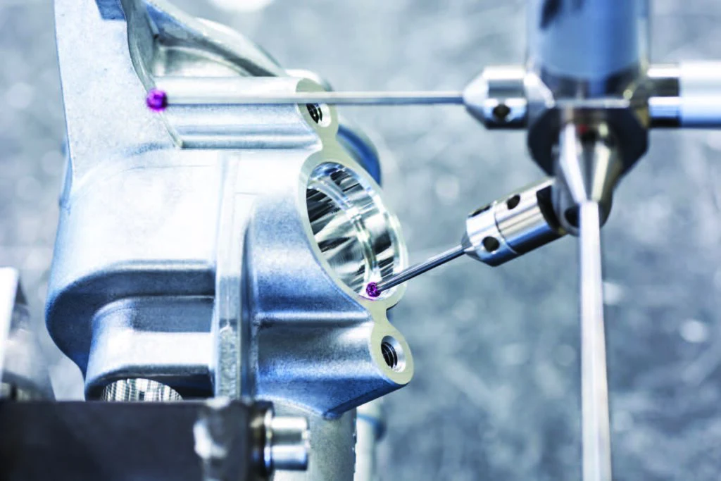 Messtaster prüft ein Aluminium-Bauteil auf einer Koordinatenmessmaschine