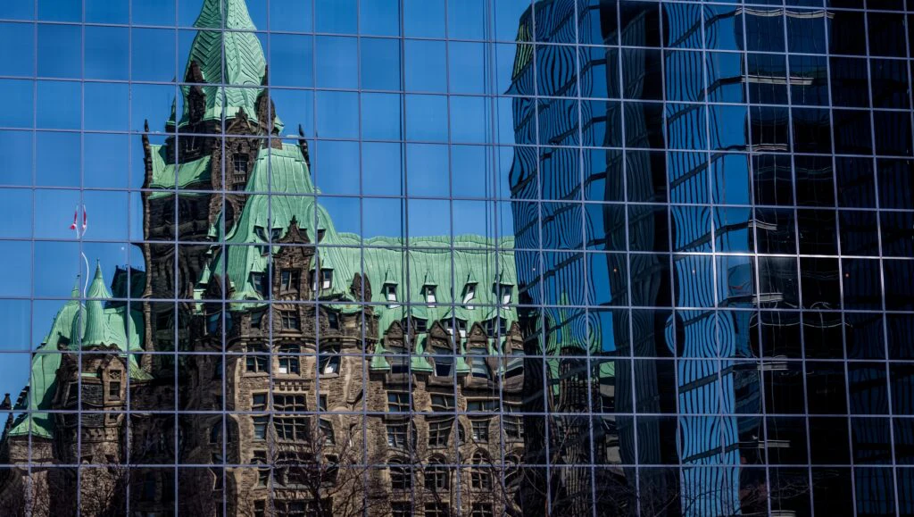 Historic administrative building reflected in a glass facade