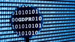 Lupe über einer Wand aus Binärcode, die das Wort GDPR sichtbar macht